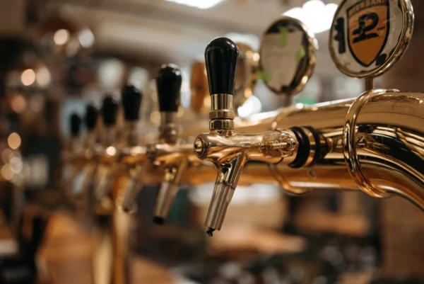 Shiny beer taps in a bar with a warm, inviting atmosphere.