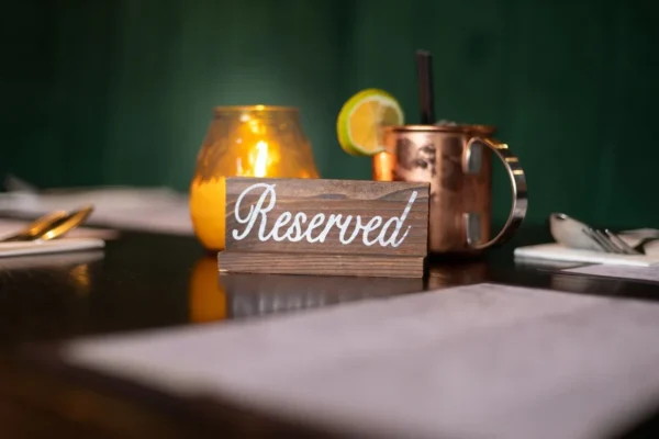 A warmly lit table featuring a reserved sign and a glowing candle, perfect for dining experiences.